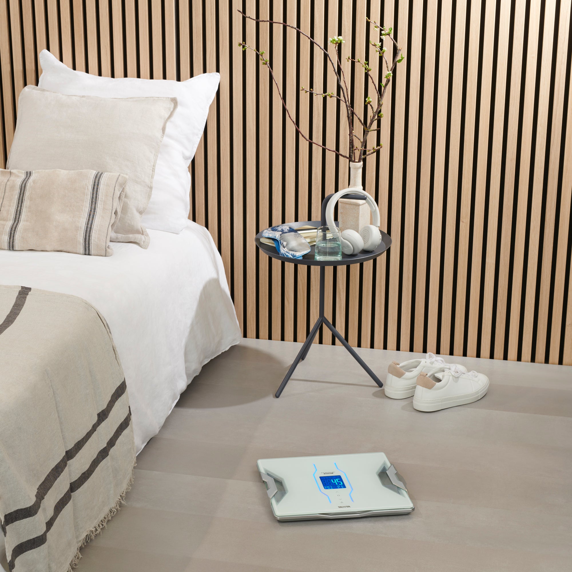 Bedroom with a bed, nightstand, and a white Tanita RD-953 Bluetooth Body Composition Monitor on the floor.